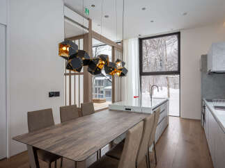 This stunning property boasts a modern, open-plan kitchen and dining area with breathtaking views of a snow-covered landscape.