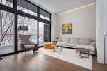 Modern living room with floor-to-ceiling windows offering stunning snowy forest views.