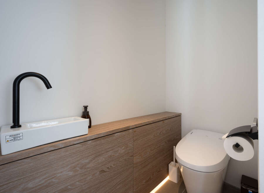 Modern bathroom boasts a sleek, minimalist design with a floating vanity and integrated sink.