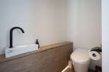 Modern bathroom boasts a sleek, minimalist design with a floating vanity and integrated sink.