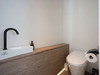 Modern bathroom boasts a sleek, minimalist design with a floating vanity and integrated sink.
