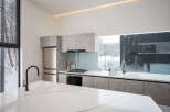 Modern kitchen with sleek countertops and integrated appliances.