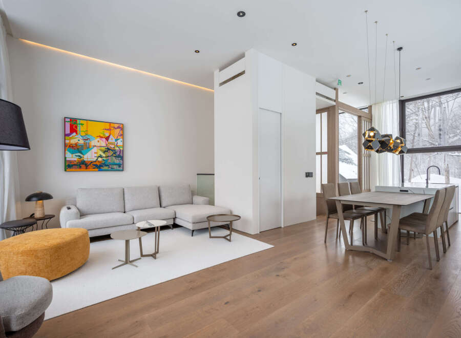 This stunning property boasts an open-concept living area with hardwood floors, a cozy sectional sofa, and large windows offering breathtaking views.
