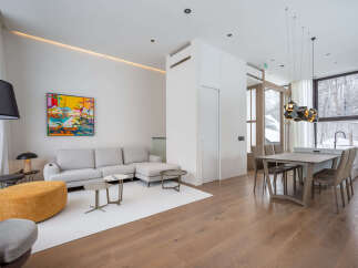 This stunning property boasts an open-concept living area with hardwood floors, a cozy sectional sofa, and large windows offering breathtaking views.