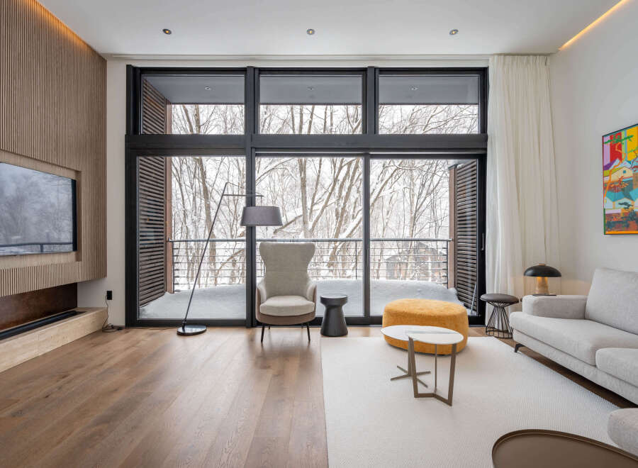 This stunning property boasts floor-to-ceiling windows offering breathtaking views of a snow-covered landscape.