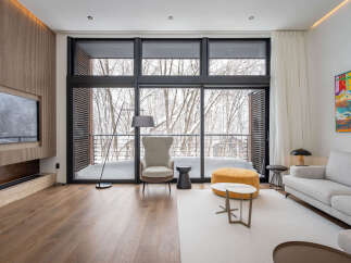 This stunning property boasts floor-to-ceiling windows offering breathtaking views of a snow-covered landscape.