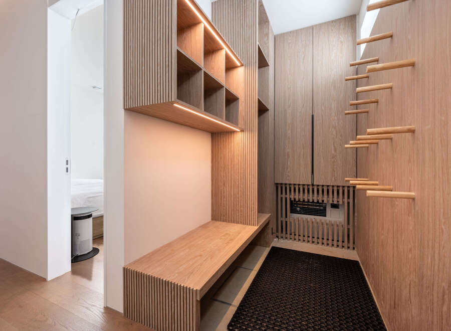 This stunning property boasts a custom-designed entryway with built-in shelving, a sleek bench, and stylish wooden accents.