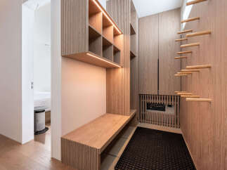 This stunning property boasts a custom-designed entryway with built-in shelving, a sleek bench, and stylish wooden accents.