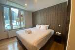Cozy bedroom with a king-size bed, featuring a large window overlooking snowy scenery.
