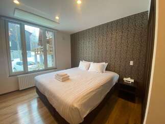 Cozy bedroom with a king-size bed, featuring a large window overlooking snowy scenery.