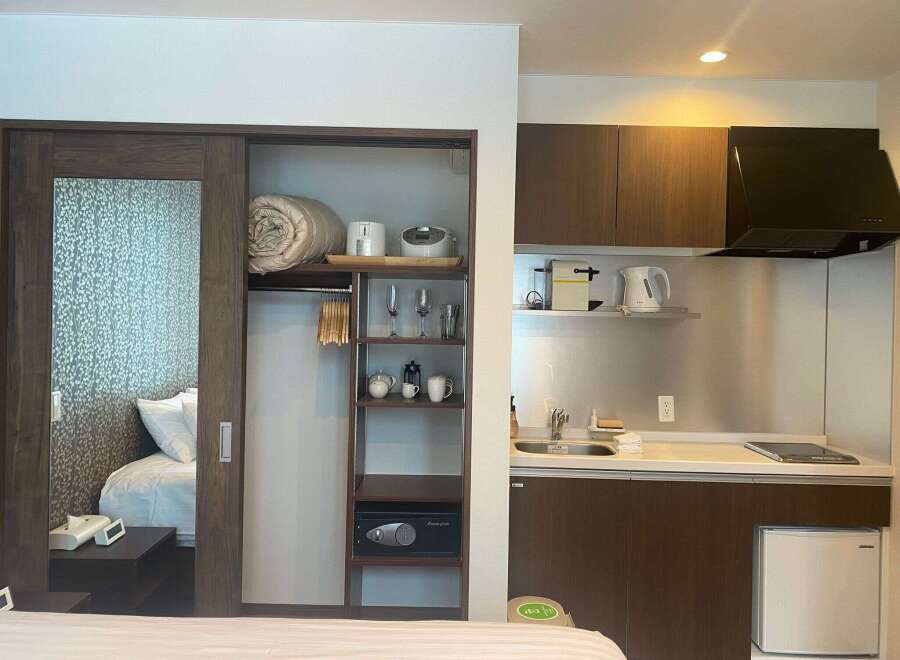 This cozy studio apartment boasts a built-in wardrobe with ample storage, a kitchenette equipped with essential appliances, and a comfortable sleeping area.