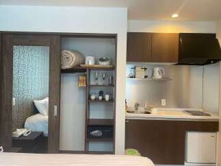 This cozy studio apartment boasts a built-in wardrobe with ample storage, a kitchenette equipped with essential appliances, and a comfortable sleeping area.