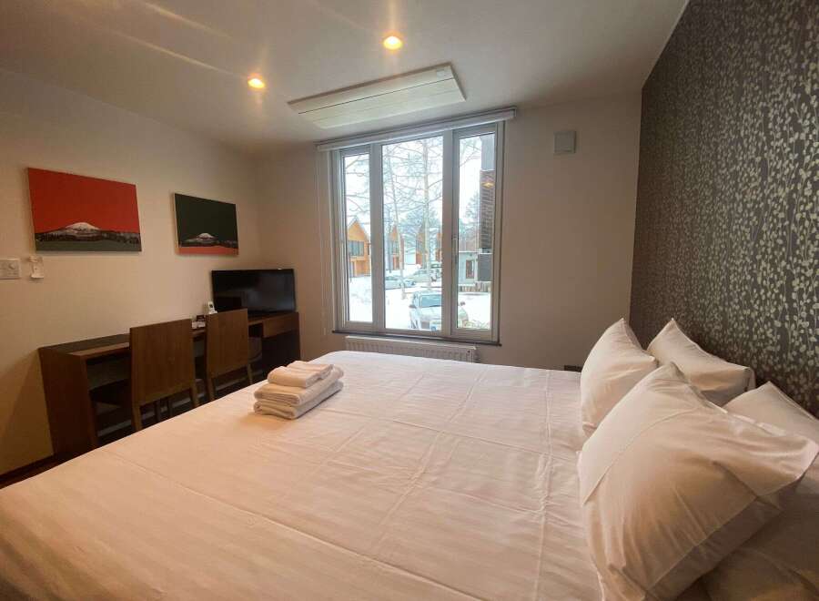Cozy bedroom with a comfortable bed, crisp white linens, and plenty of pillows.