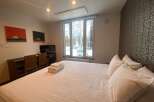 Cozy bedroom with a comfortable bed, crisp white linens, and plenty of pillows.