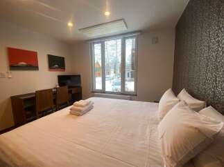 Cozy bedroom with a comfortable bed, crisp white linens, and plenty of pillows.