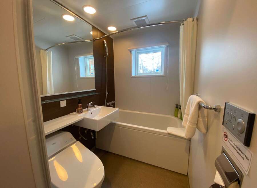 This modern bathroom boasts a sleek design with a bathtub, toilet, and sink.