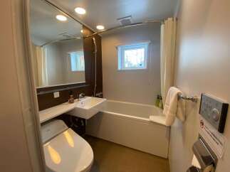 This modern bathroom boasts a sleek design with a bathtub, toilet, and sink.