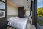 Luxurious hotel room with a king-size bed, stunning mountain views, and a modern kitchenette.