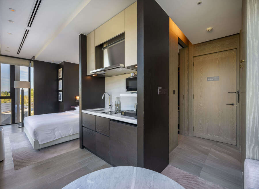 This modern hotel room boasts a stylish kitchenette, perfect for a comfortable stay.