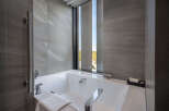 Indulge in tranquility with our luxurious bathroom featuring a freestanding bathtub and floor-to-ceiling windows offering breathtaking views.