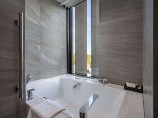 Indulge in tranquility with our luxurious bathroom featuring a freestanding bathtub and floor-to-ceiling windows offering breathtaking views.