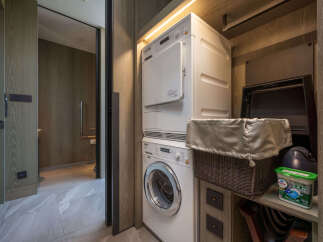 This luxurious property boasts a modern laundry closet complete with Miele washer and dryer, conveniently tucked away for ultimate convenience.