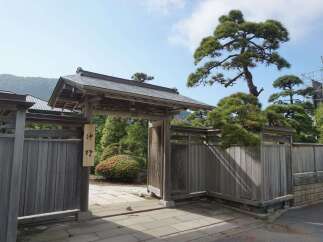 Discover serenity at this exquisite property, featuring a traditional Japanese gate and meticulously landscaped gardens.