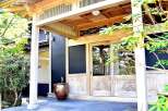 This stunning Japanese-style home features a spacious entryway with a beautiful wooden door and a serene garden view.