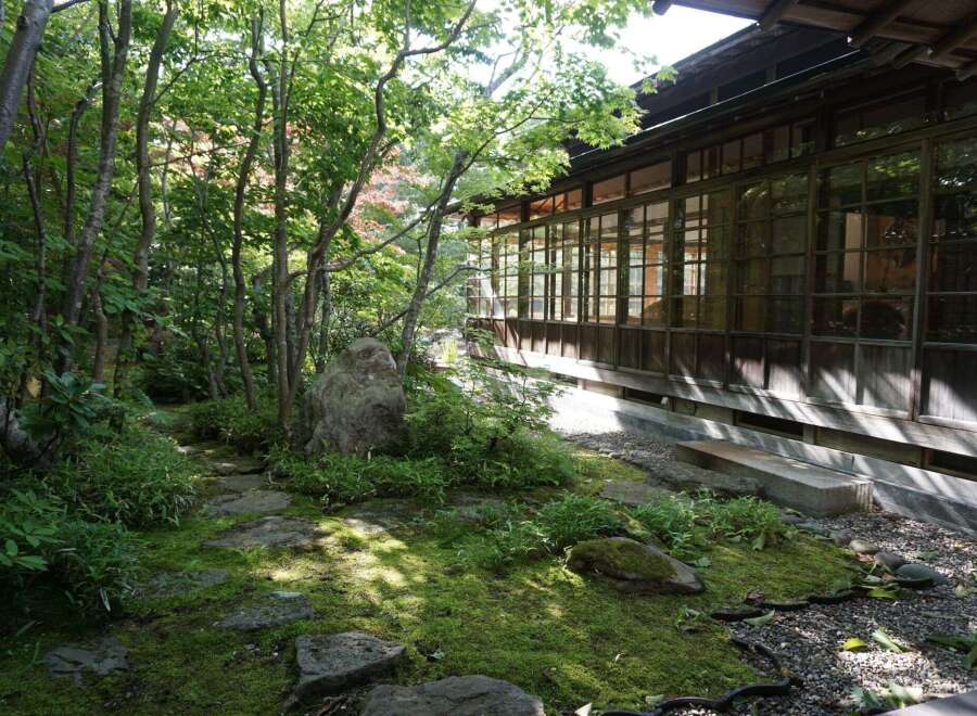Discover serenity in this meticulously landscaped Japanese garden, featuring a moss-covered path, ancient stones, and lush greenery.