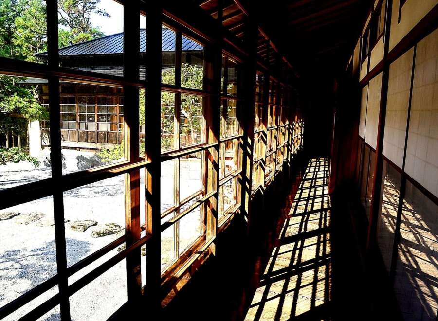This stunning Japanese-style hallway boasts floor-to-ceiling windows offering breathtaking garden views.