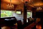 Luxurious living room with stunning chandeliers and a stone wall feature.