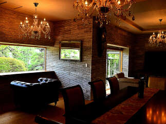 Luxurious living room with stunning chandeliers and a stone wall feature.