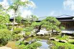 Discover serenity in this Japanese garden, featuring a tranquil pond, meticulously manicured landscaping, and traditional wooden buildings.