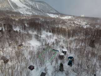 Mountain view lot in a snowy forest setting.
