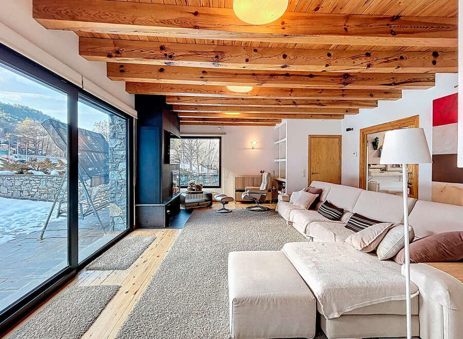 Experience luxury living in this stunning property, featuring a spacious living area with a cozy fireplace and expansive windows that offer breathtaking views of the surrounding landscape.