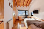 This cozy bedroom features a warm wooden ceiling and flooring, creating a comfortable and inviting atmosphere.