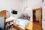 This cozy bedroom features a modern design with a comfortable bed and a mounted TV for entertainment.