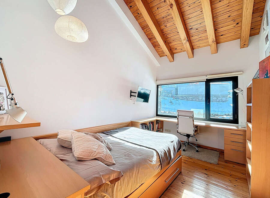 Discover the charm of this inviting bedroom, featuring a unique wooden ceiling and ample natural light.