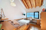 Discover the charm of this inviting bedroom, featuring a unique wooden ceiling and ample natural light.