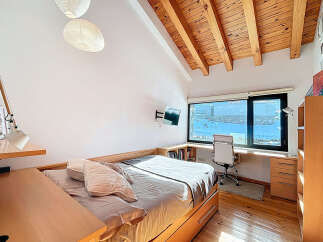 Discover the charm of this inviting bedroom, featuring a unique wooden ceiling and ample natural light.