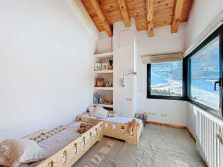 This charming bedroom features a cozy design with wooden accents and a bright, airy feel.