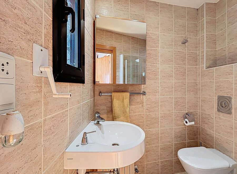 This charming bathroom features a modern corner sink, perfect for maximizing space.