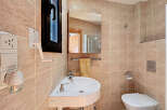 This charming bathroom features a modern corner sink, perfect for maximizing space.