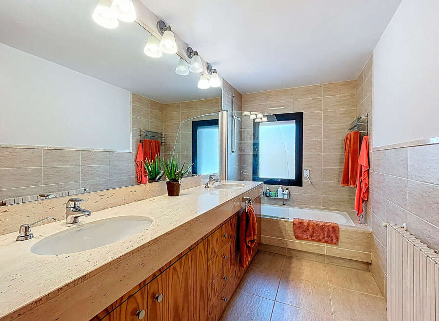 This modern bathroom features a sleek design with a large vanity and ample storage.