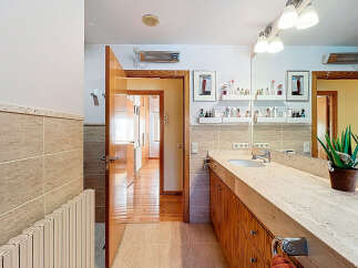 Step into this beautifully designed bathroom, featuring a sleek countertop and stylish wooden cabinetry.
