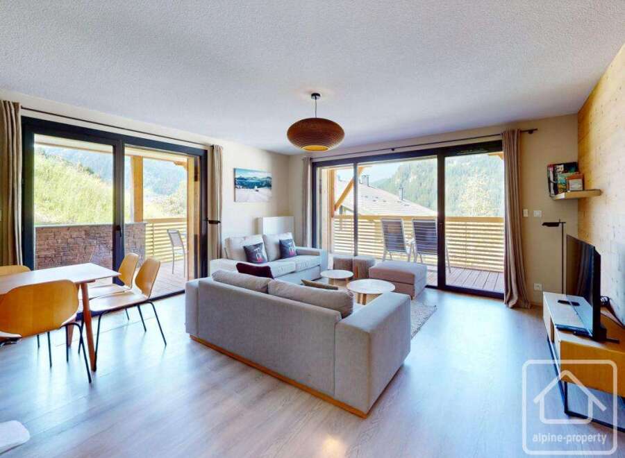 This stunning apartment boasts a spacious open-plan living area with floor-to-ceiling windows offering breathtaking mountain views.