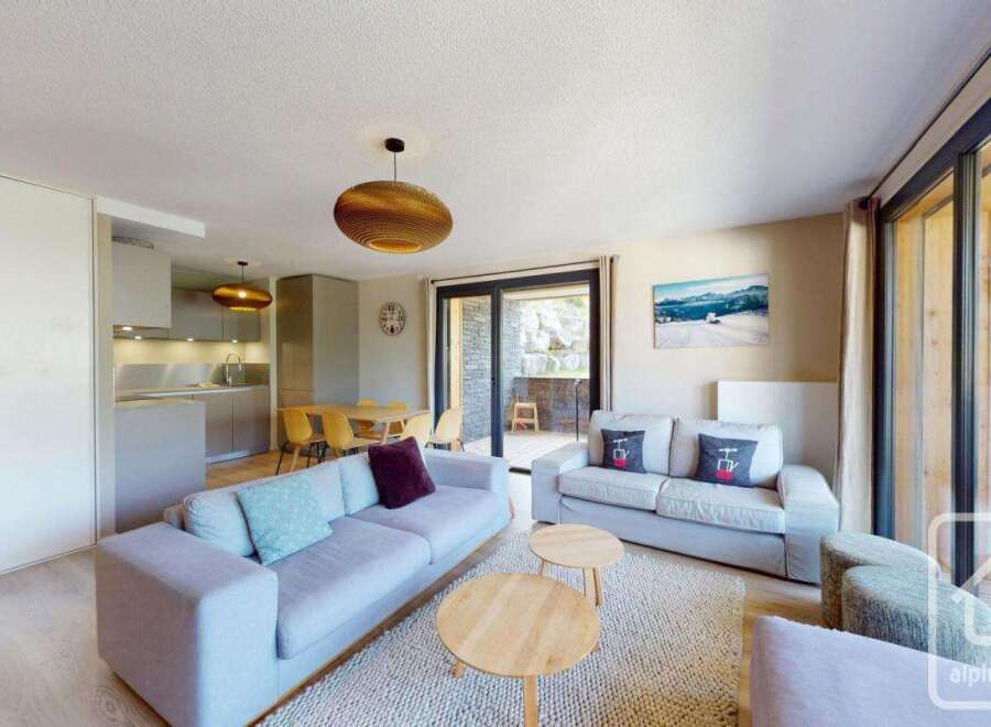 This stunning apartment boasts an open-plan living area with modern furnishings and a spacious balcony offering breathtaking mountain views.