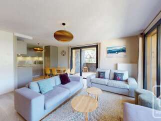 This stunning apartment boasts an open-plan living area with modern furnishings and a spacious balcony offering breathtaking mountain views.