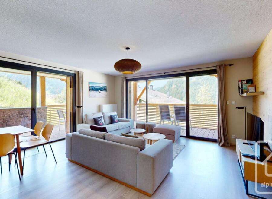 This stunning apartment boasts an open-plan living area with floor-to-ceiling windows offering breathtaking mountain views.
