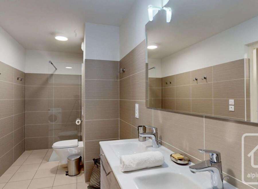 Modern bathroom with double sinks, a walk-in shower, and stylish tile.